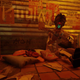 A cat sits next to a robot playing guitar in Stray.